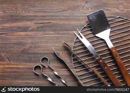new metallic barbecue utensils wooden background. Beautiful photo. new metallic barbecue utensils wooden background