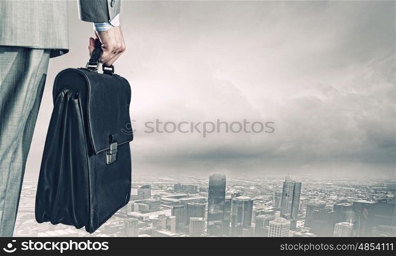 New opportunities. Back view of businessman with suitcase looking at city