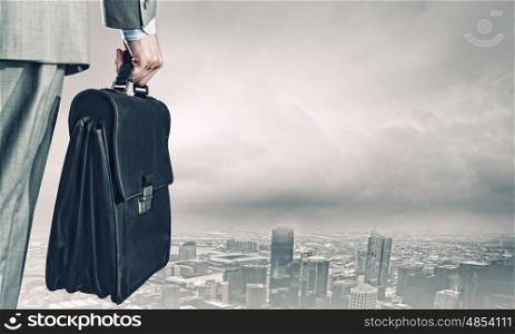 New opportunities. Back view of businessman with suitcase looking at city