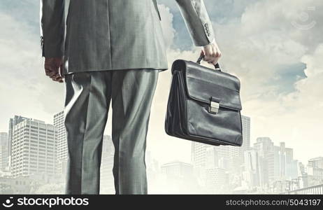 New opportunities. Back view of businessman with suitcase walking on road