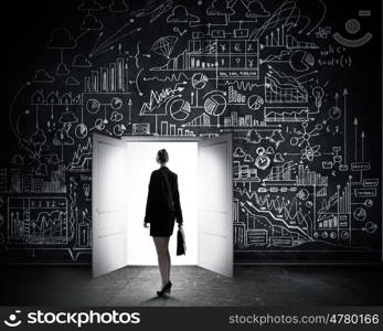 New opportunities. Rear view of businesswoman looking at opened door