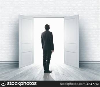 New opportunity. Image of businessman standing in front of opened door