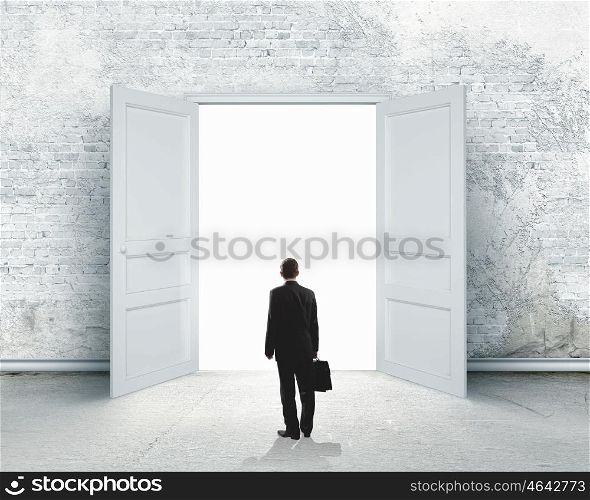 New opportunity. Image of businessman standing in front of opened door