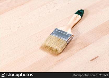 new paint brush on beech wooden furniture board