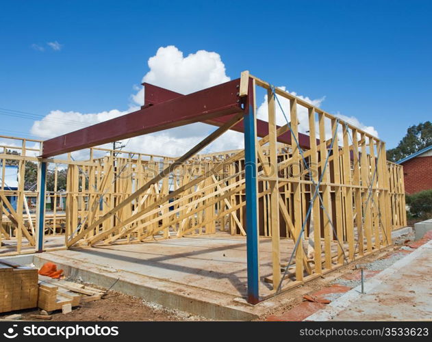 New residential construction home framing against a blue sky