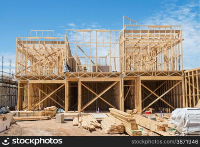 New residential construction home framing against a blue sky.