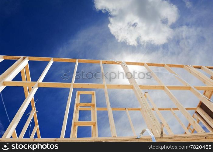 New residential construction home framing against a blue sky