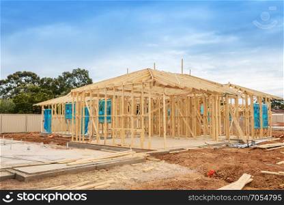 New residential construction home framing against a blue sky.Construction site preparation