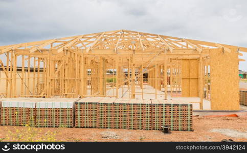 New residential construction home framing against a cloudy sky