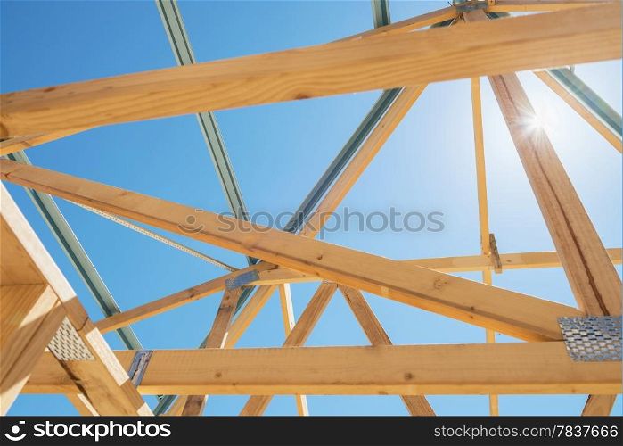 New residential construction home framing against a sunny sky.