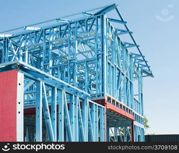 New residential construction home metal framing against a blue sky