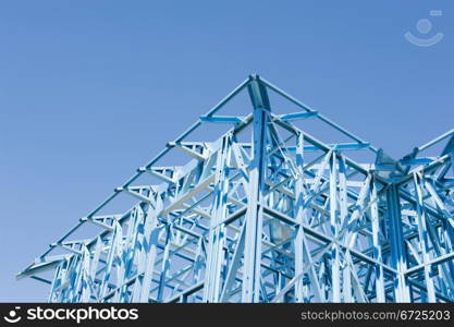 New residential construction home metal framing against a blue sky