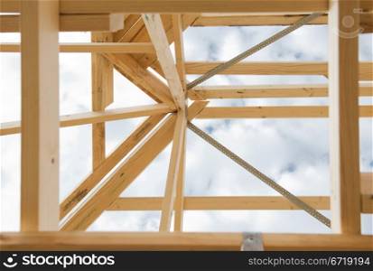 New residential construction home wooden framing against a cloudy sky