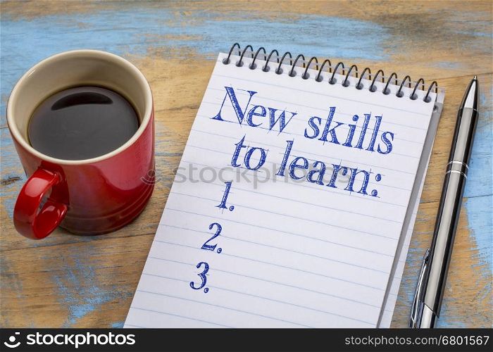 New skills to learn list in notebook a spiral notebook with a cup of coffee, goal setting and resolutions concept
