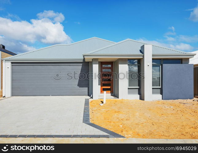 new suburban house in the final stages of construction against cloudy sky