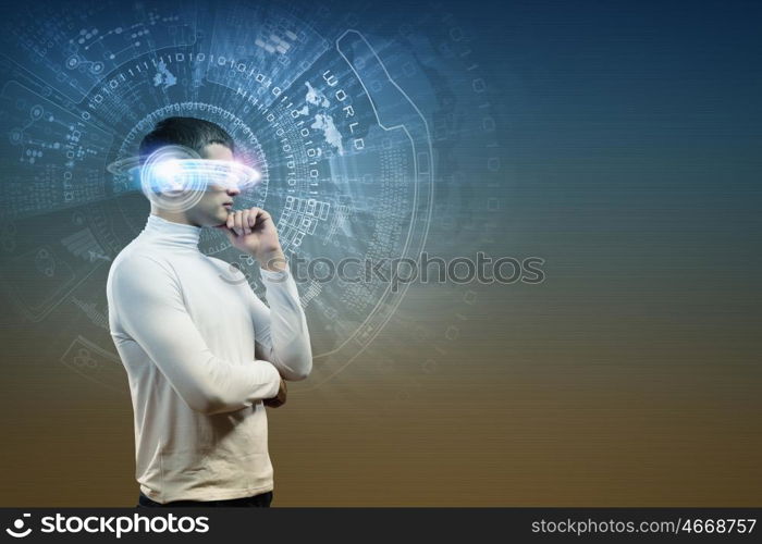 New technologies. Young man in white against blue background with hologram around head