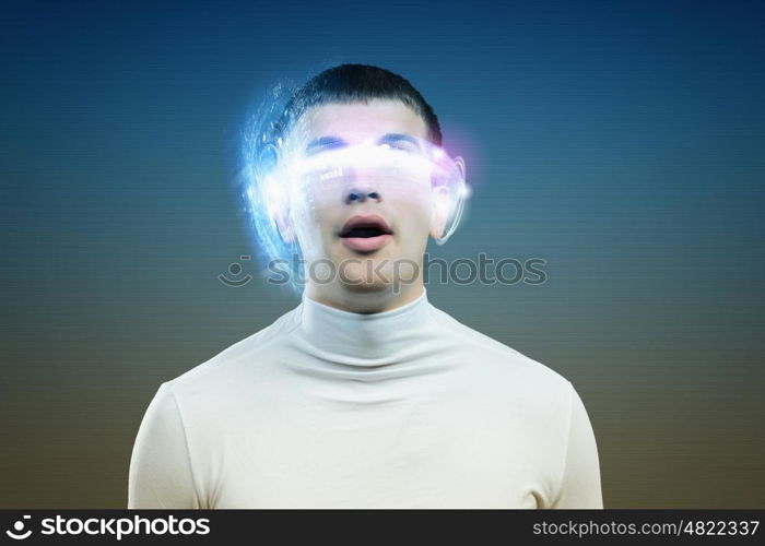 New technologies. Young man in white against blue background with hologram around head