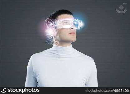 New technologies. Young man in white against blue background with hologram around head