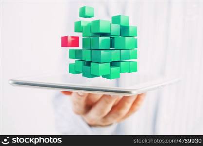 New technology integration concept. Businessman holding tablet and 3D rendering cube as symbol of problem solving