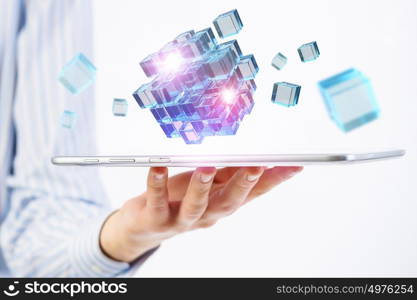 New technology integration concept. Businessman holding tablet and 3D rendering cube as symbol of problem solving