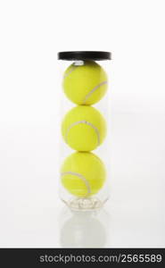 New tennis balls stacked in plastic container.