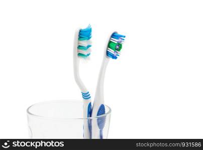 New toothbrush and old toothbrush (damaged) in clear glass for teeth cleaning isolated on white background . With clipping path