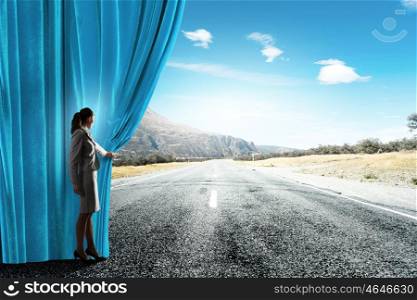 New ways and perspectives. Young businesswoman opening stage curtain to another reality