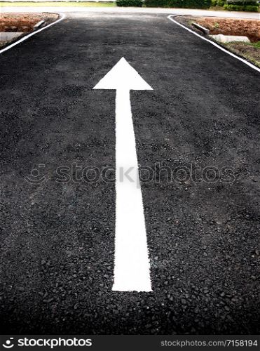 new white arrow on new asphalt black road