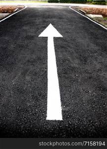 new white arrow on new asphalt black road