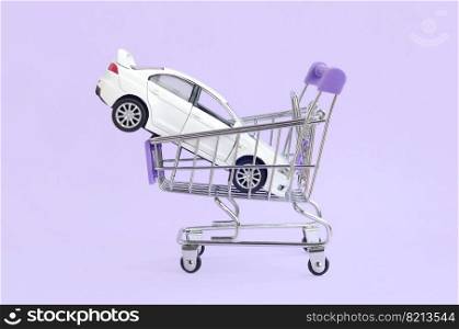 New white toy car in shopping cart as a symbol for car buying and leasing. Car buying and leasing concept. Vehicle in shopping cart