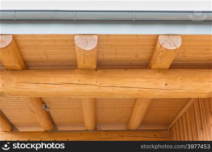 New wooden roof construction of house with tree trunks