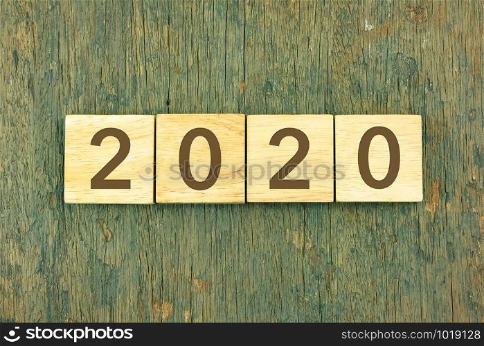 New Year 2020 concept with typography on blocks over wooden texture background. Vintage and retro style for new year celebration, end of the year and winter season.