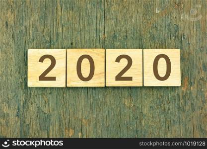 New Year 2020 concept with typography on blocks over wooden texture background. Vintage and retro style for new year celebration, end of the year and winter season.