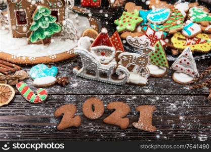 New year 2021 concept: holiday gingerbreads on wooden background, xmas and christmas theme. New year 2021 concept