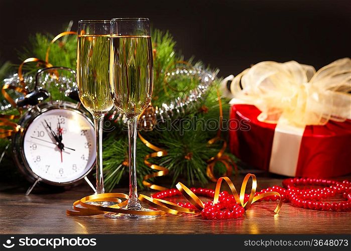 New Year&acute;s still life with glasses of champagne. Decorations and ribbons on a bright color background