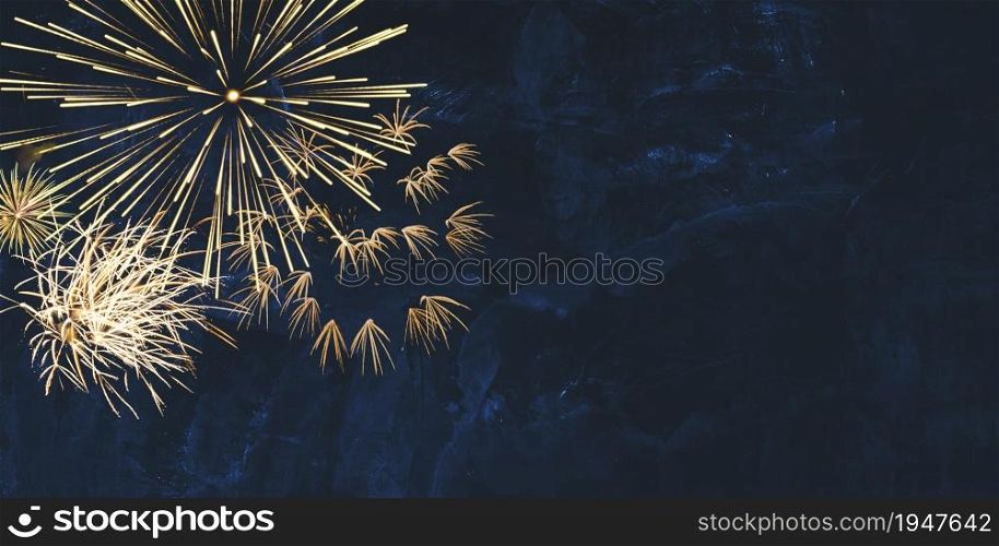 New year background banner panorama image of golden firework sparklers on dark blue night sky texture with copy space for text
