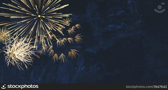 New year background banner panorama image of golden firework sparklers on dark blue night sky texture with copy space for text