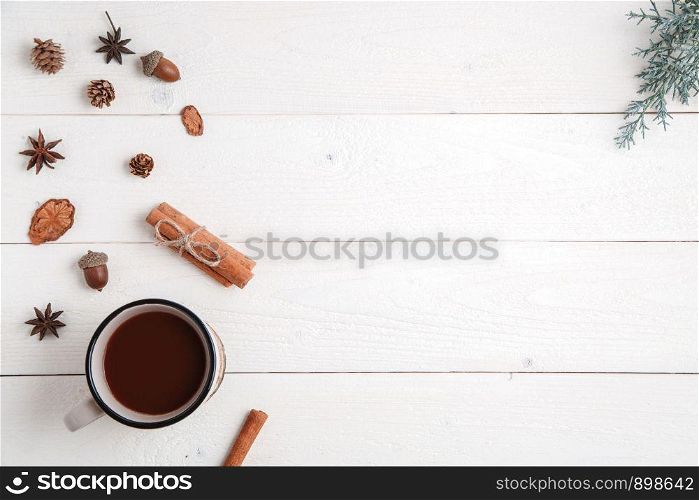 new year background. cinnamon,anise stars,fir branches and a Cup of hot chocolate on a white wooden background. Flat lay. top view