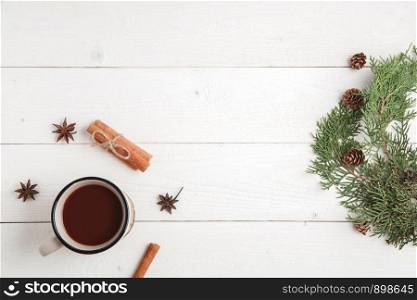 new year background. cinnamon,anise stars,fir branches and a Cup of hot chocolate on a white wooden background. Flat lay. top view