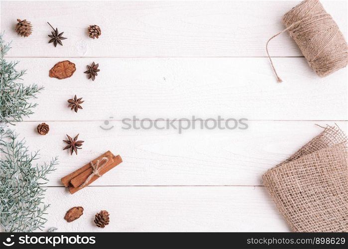 new year background. flatlay. cinnamon,fir branches on white wooden background,fabric and threads for gift packaging