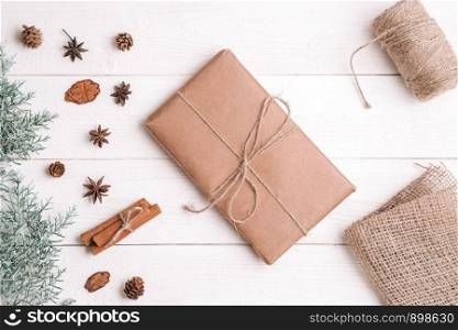new year background. flatlay. cinnamon,spruce branches and Christmas gift on white wooden background