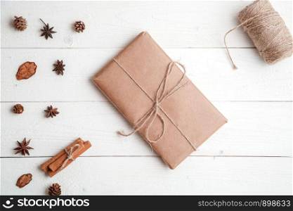 new year background. flatlay. cinnamon,spruce branches and Christmas gift on white wooden background