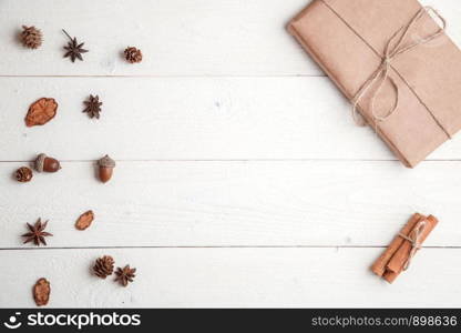 new year background. flatlay. cinnamon,spruce branches and Christmas gift on white wooden background