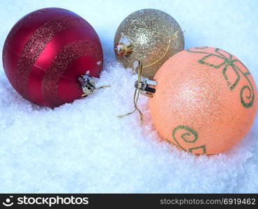 New Year background of three different colored Christmas balls in the snow
