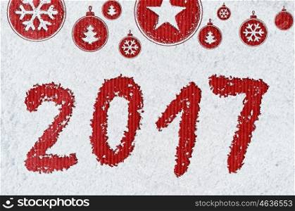 new year background on snow. christmas card or new year background made of xmas symbols handwritten on snow and red craft paper