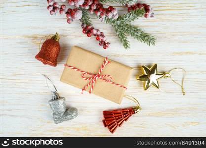 New year background with christmas tree branch, decorative fir tree, fir cones and gift box on white wooden background with space for text. Flat lay, top view.. Christmas background with decorations and gift box on white wooden board