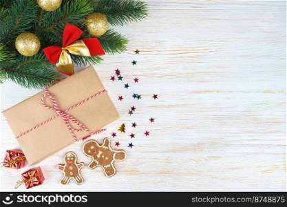 New year background with christmas tree branch, gingerbread man and gift box on white wooden background with copy space. Flat lay, top view.. Christmas background with decorations and gift box on white wooden board