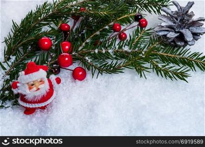 New Year background with Santa Claus spruce branch and red berries on snow