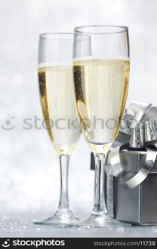 New year card with Champagne and gift on shiny glitter background