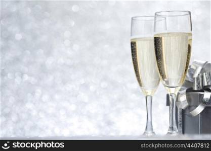 New year card with Champagne and gift on shiny glitter background